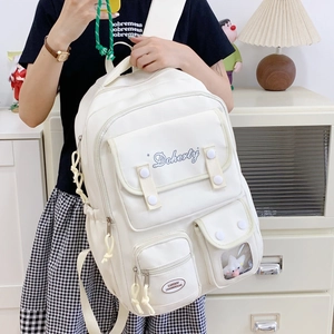 Détail d'un sac à dos blanc cassé avec plusieurs poches et fenêtre transparente