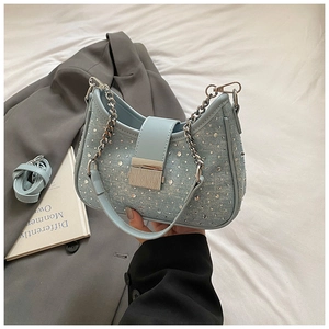 Detail of light blue denim bag with sparkling rhinestones and silver metal buckle