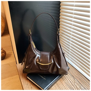 Gros plan détaillé d'un sac à main en cuir marron foncé brillant avec détails dorés