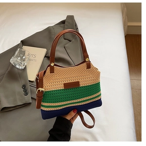 Detail of striped knitted bucket bag with brown leather handles and adjustable strap