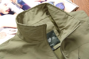 Detail of army green outdoor vest showing stand collar with mesh lining and zipper