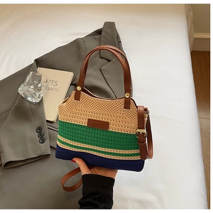 Detail of tricolor woven bag featuring green and blue stripes with leather strap