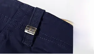 Détail macro des passants de ceinture avec coutures précises et plaque en métal vintage