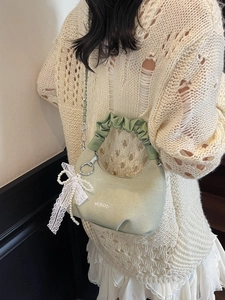 Light green pleated dumpling bag with lace bow and pearl charm worn by model