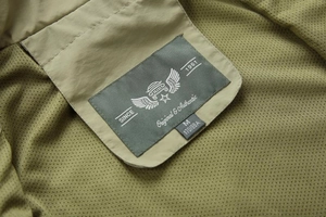 Detail of the olive green casual vest collar with breathable mesh lining and size label