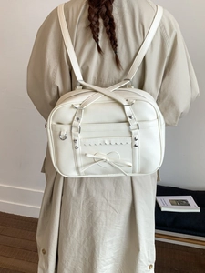 White faux leather backpack with heart embroidery and bow detail shown from back view