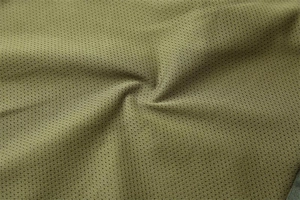 Detailed macro view of breathable army green honeycomb mesh fabric for tactical vests