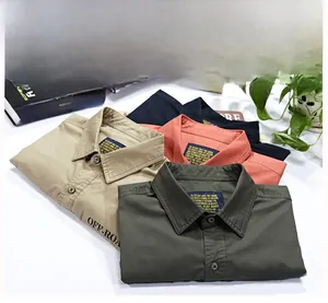 Close-up of short-sleeve men's cargo shirts in khaki, olive green, orange, and navy colors