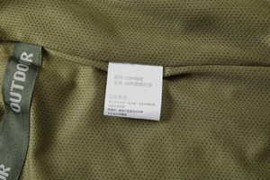 Detail of breathable mesh lining and brand label on an olive green casual outdoor vest