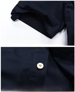 Detail of dark blue cotton shirt showing sleeve cuffs, white buttons and precise stitching