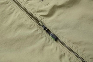 Detail of metal zipper and durable olive green fabric on the casual outdoor vest