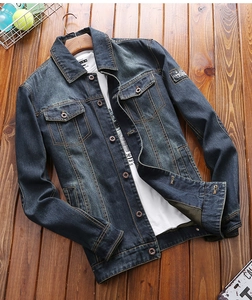 Detailed view of dark blue denim jacket collar and vintage pocket with COWBOY patch