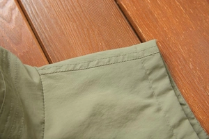 Detail of reinforced double-stitching on the seam of an olive green casual vest fabric