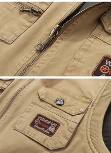 Close-up of bronze zippers and durable stitching on a khaki multi-pocket outdoor vest