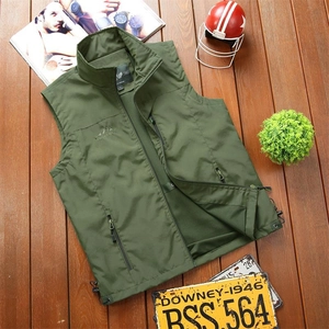 Military green outdoor functional vest with zip pockets and mesh lining on wood floor
