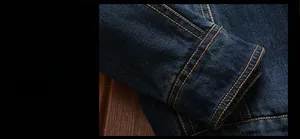 Detailed view of dark blue denim jacket cuff with classic orange double stitching