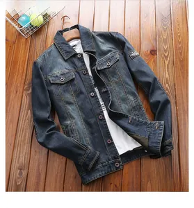 Flat lay of a dark blue denim jacket with turn-down collar and decorative sleeve patch