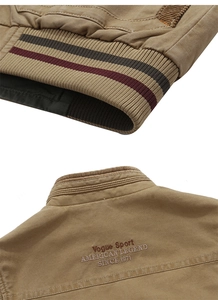 Detail of khaki cotton vest with striped ribbed hem and vintage embroidery on the back