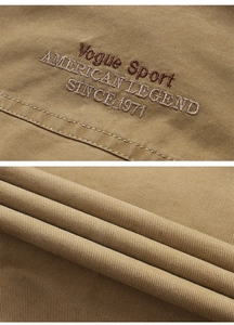 Detail of khaki twill vest featuring vintage embroidery and durable fabric texture