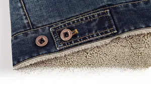 Détail de l'ourlet de la veste en jean bleu foncé avec doublure en molleton beige