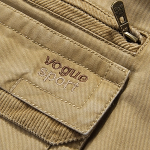 Close-up of khaki cotton outdoor vest showing corduroy texture and zip pocket detail