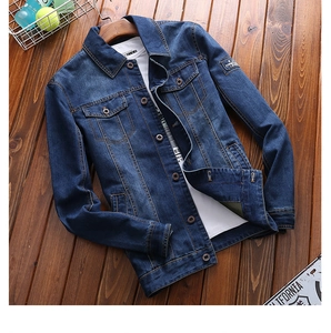 Detailed view of dark blue denim jacket with vintage wash and embroidered sleeve patch