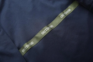 Macro shot of breathable dark blue mesh fabric with an olive green Outdoor tape detail