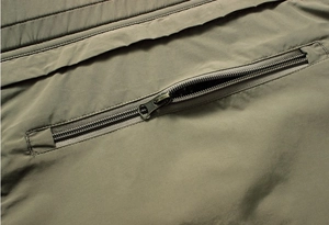 Detail shot of heavy-duty metal zipper pocket on olive green outdoor tactical vest