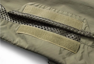 Macro shot of army green fishing vest with velcro closure and breathable mesh lining