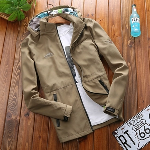 Men's khaki hooded outdoor jacket with camouflage lining on rustic wooden background