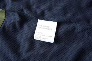Detail view of clothing wash care label and breathable mesh lining of the navy blue vest