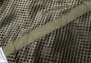 Close-up of military green breathable mesh fabric with reinforced stitching on tactical vest