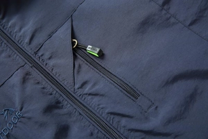 Detail of navy blue outdoor vest featuring a zipper pocket and outdoor embroidery