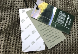 Detailed close-up of garment tags on brown mesh fishing vest with care instructions