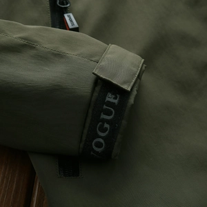 Olive green hooded jacket with adjustable magic tape cuffs and decorative Vogue webbing