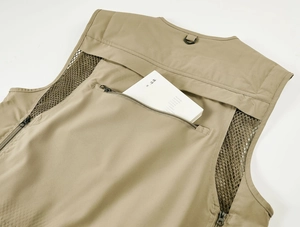 Détail du dos du gilet de pêche kaki montrant une grande poche zippée et des inserts en mesh