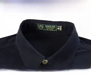 Close-up of dark blue stand collar with bronze metal button and interior brand label