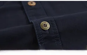 Detail of navy blue cotton shirt placket with vintage bronze engraved metal buttons