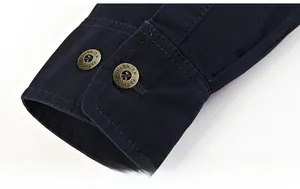 Detailed view of navy blue shirt cuff featuring double stitching and metal fashion buttons
