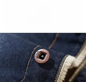Detail of vintage copper button with SPIRIT engraving on thick denim jacket with fleece lining