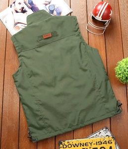 Detail of army green outdoor vest back featuring classic leather patch and adjustable hem