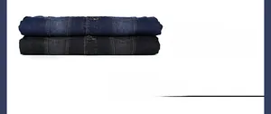 Dettaglio di giacche di jeans piegate in blu e grigio scuro con cuciture gialle e bottoni