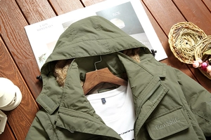 Detail of army green hooded parka jacket with warm fleece lining and classic embroidery
