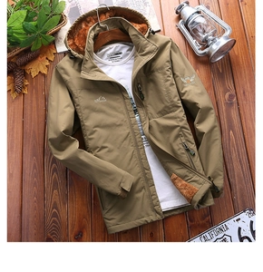 Detail of khaki outdoor hooded jacket with warm brown fleece lining on wooden floor