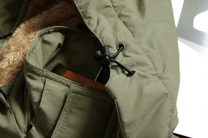 Detail of army green hooded jacket with fleece lining and adjustable drawstring