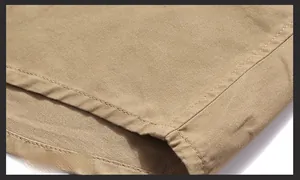 Detail of the khaki military shirt hem showing double-needle stitching and fabric texture
