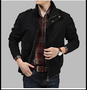 Detail view of black military style stand collar jacket with metallic snap epaulets and pockets