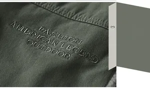 Detail of high-density embroidery on army green outdoor jacket featuring twill cotton fabric