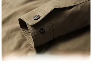 Detail of khaki twill jacket sleeve featuring a metallic snap button with fashion engraving