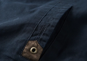 Détail de poche de veste en sergé bleu avec triple couture et garniture en daim